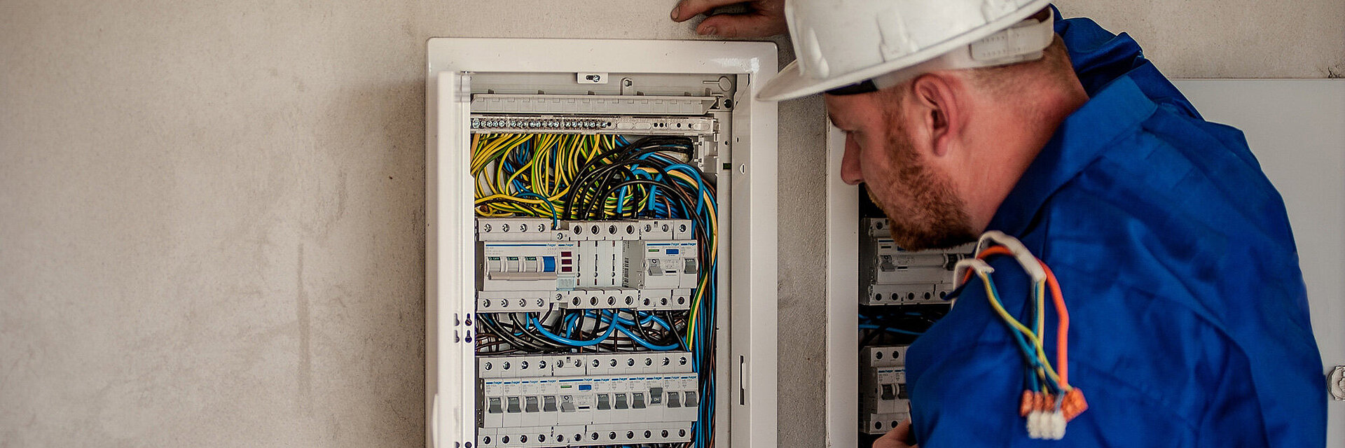 Elektriker schaut prüfend in die Zähleranlage