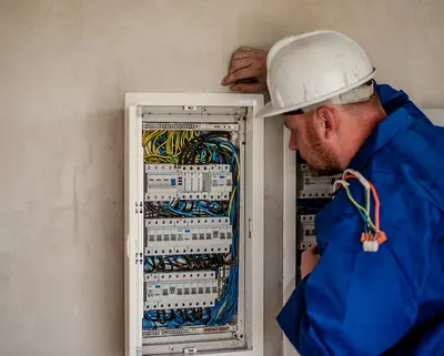 Elektriker schaut prüfend in die Zähleranlage